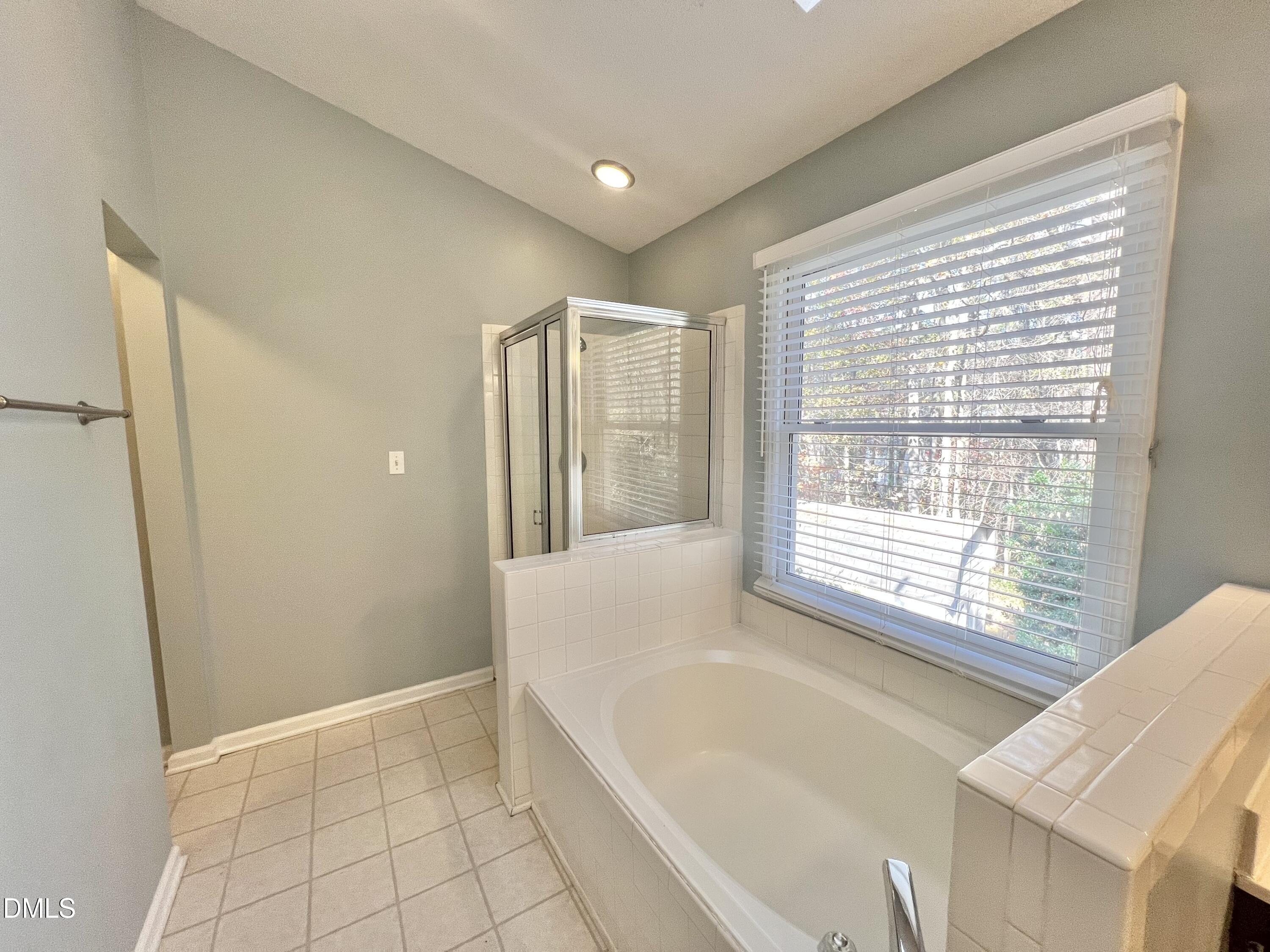 1713 Tealwood Place Raleigh, NC 27615 - Photo 16 of 26 a spacious bathroom with a bathtub and a shower