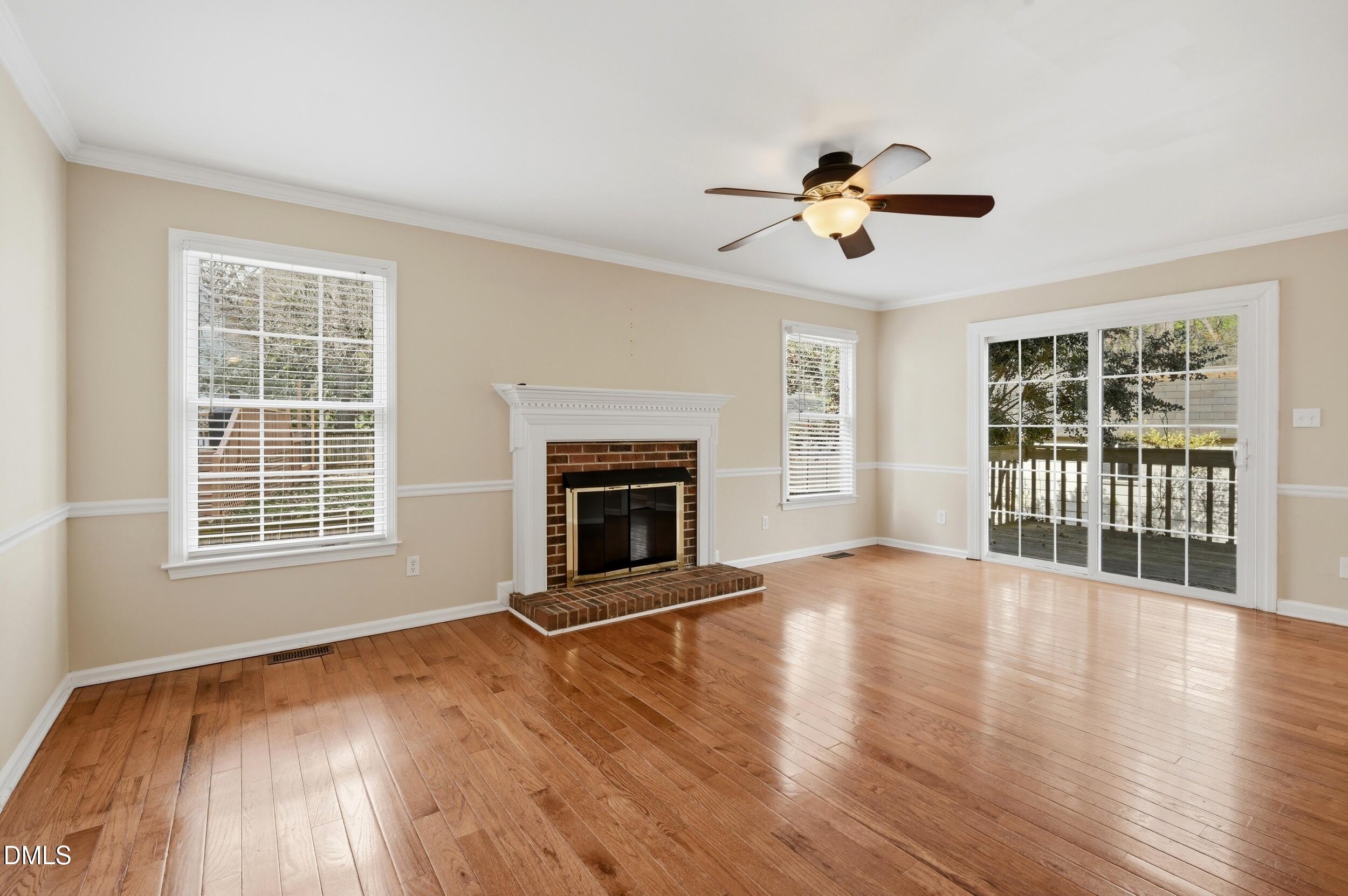1713 Tealwood Place Raleigh, NC 27615 - Photo 8 of 26 a view of an empty room with a window and wooden floor