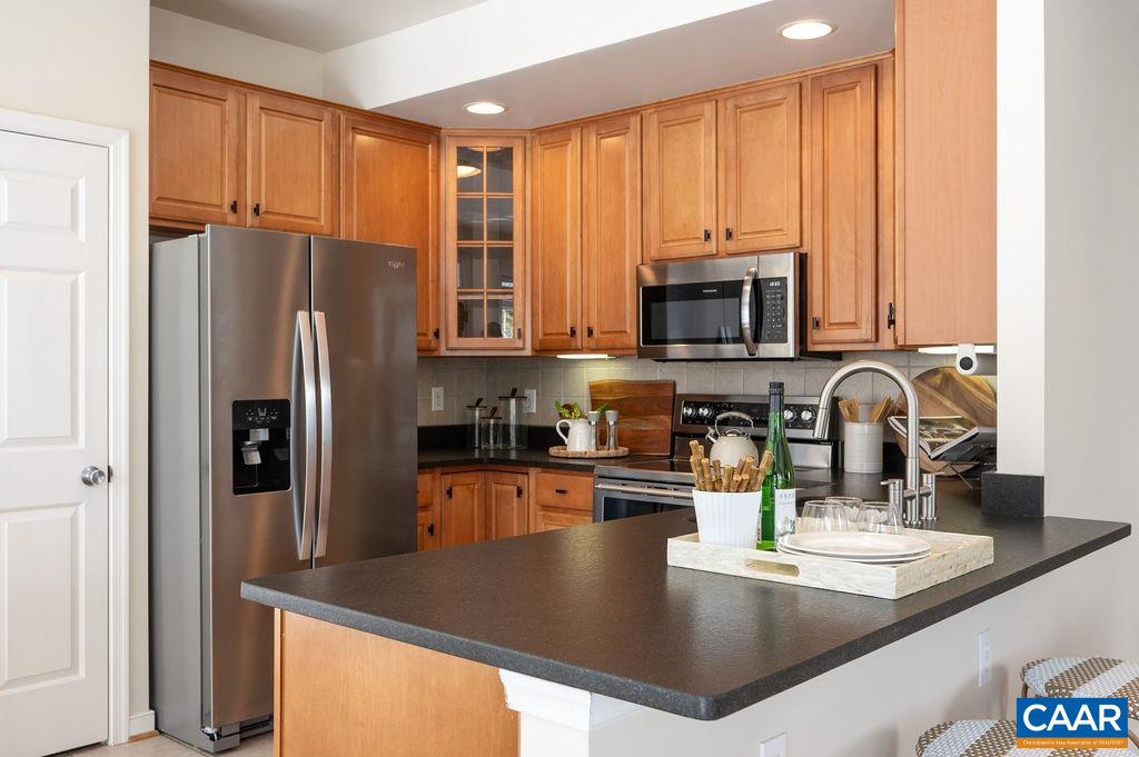732 Russet Road Crozet, VA 22932 - Photo 12 of 48 a kitchen with stainless steel appliances granite countertop a refrigerator a stove and a sink with wooden cabinets