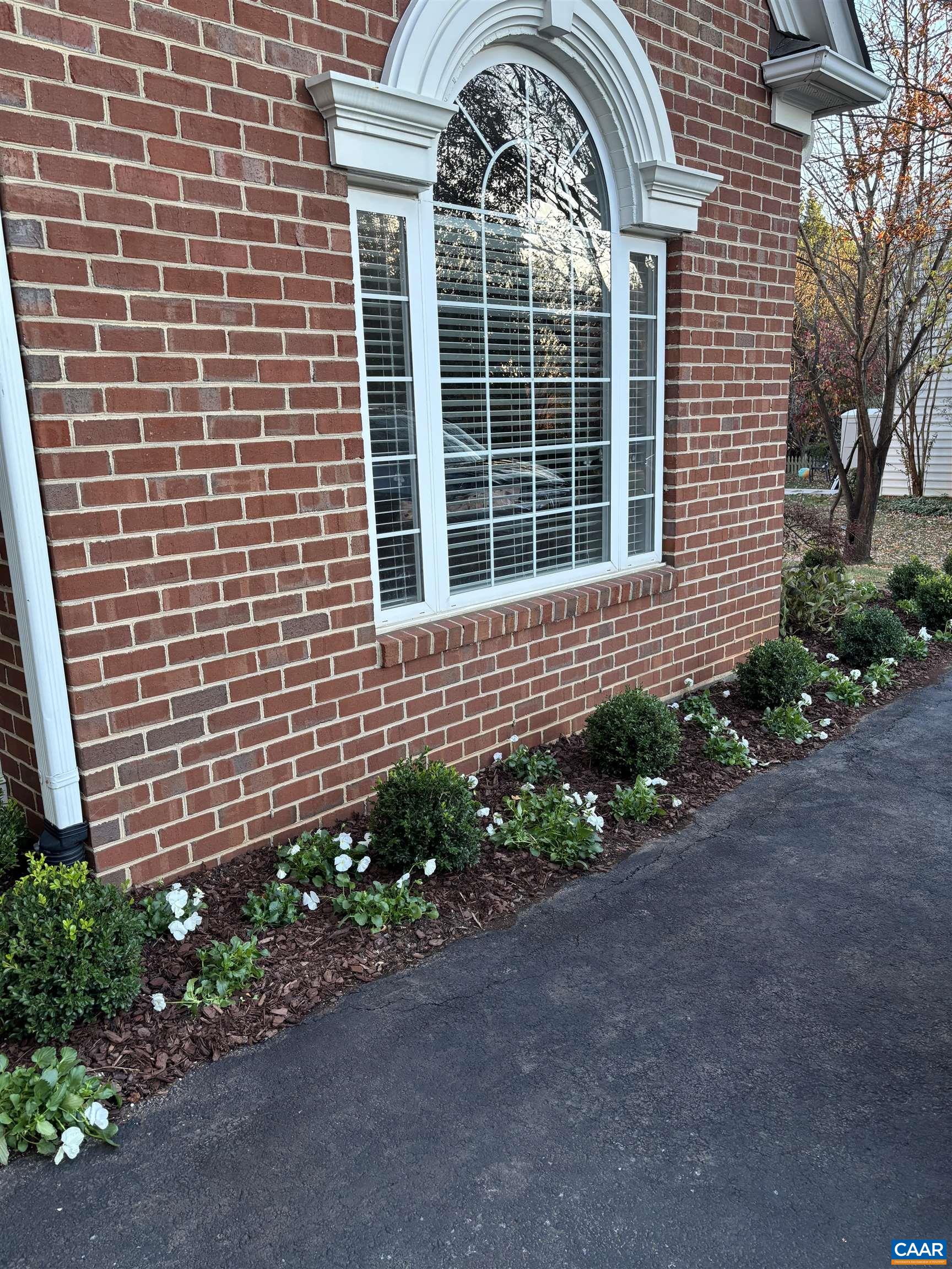 732 Russet Road Crozet, VA 22932 - Photo 38 of 48 a view of a brick house with a flower garden in front of it