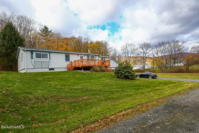 a backyard of a house with plants and large trees