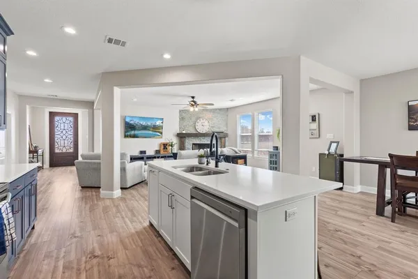 a kitchen with sink stove and wooden floor
