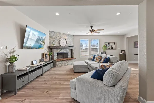 a living room with furniture a fireplace and a large window