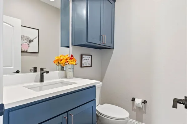 a bathroom with a sink vanity mirror and toilet