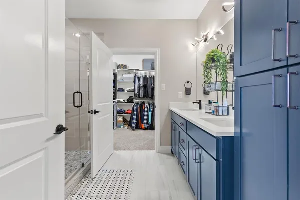 a bathroom with a granite countertop sink a mirror and shower
