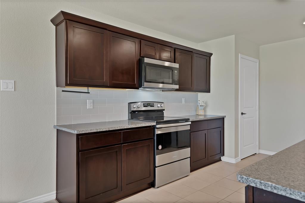 7450 Briar Road Azle, TX 76020 - Photo 14 of 40 a kitchen with stainless steel appliances granite countertop a stove microwave and sink