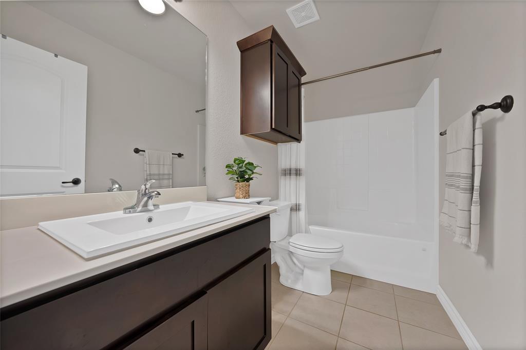 7450 Briar Road Azle, TX 76020 - Photo 24 of 40 a bathroom with a sink a toilet and mirror