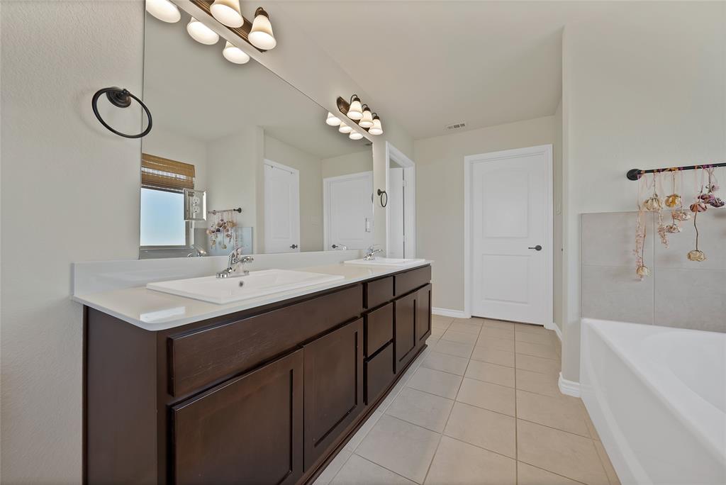 7450 Briar Road Azle, TX 76020 - Photo 28 of 40 a bathroom with a sink a mirror and a bathtub
