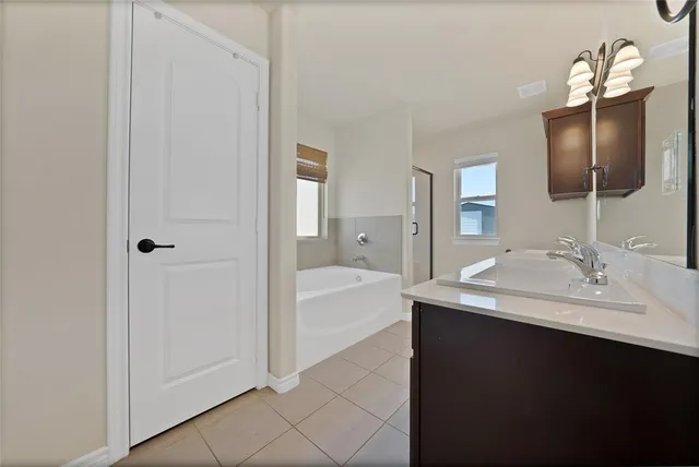 a en suite bathroom with a sink double vanity granite and a mirror