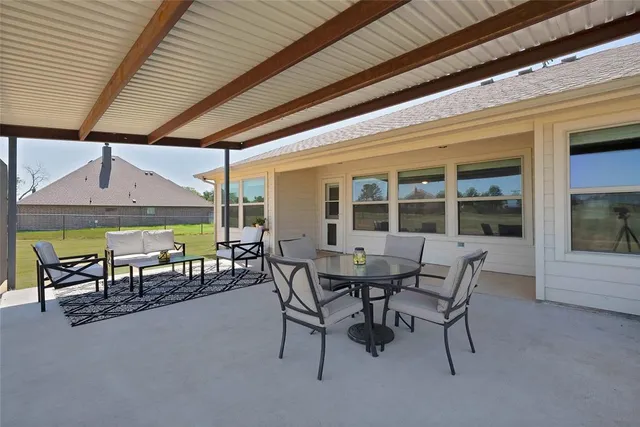 a view of a patio with table and chairs under an umbrella
