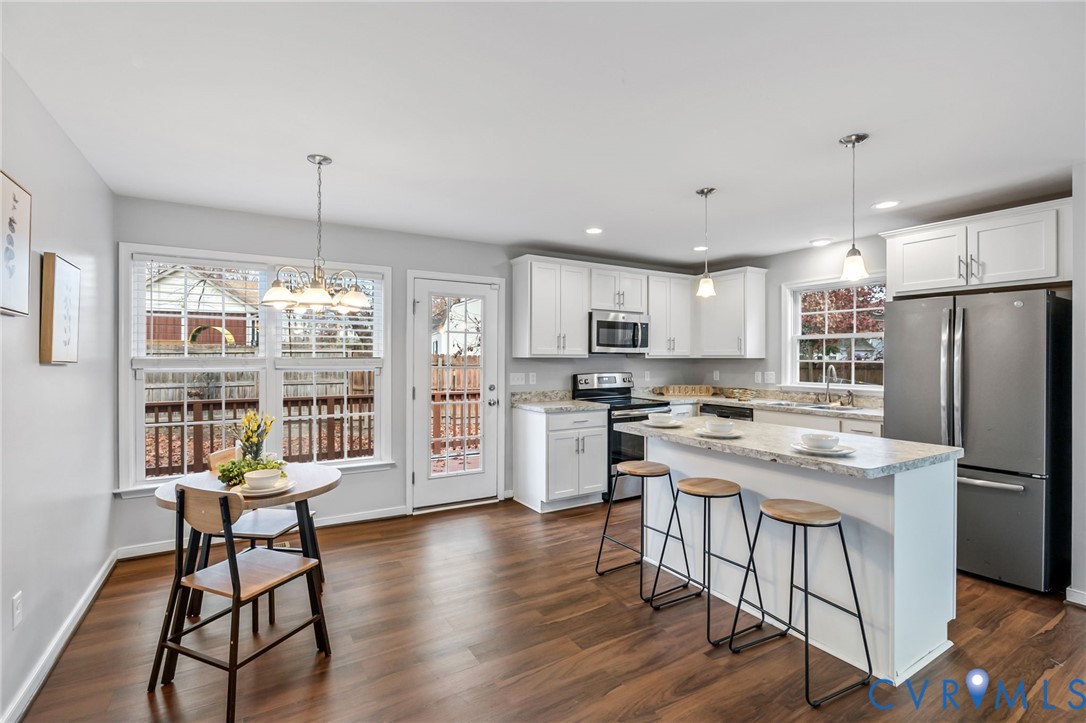 3200 Ludgate Road Chester, VA 23831 - Photo 5 of 33 a kitchen with stainless steel appliances granite countertop a stove refrigerator a dining table and chairs with wooden floor