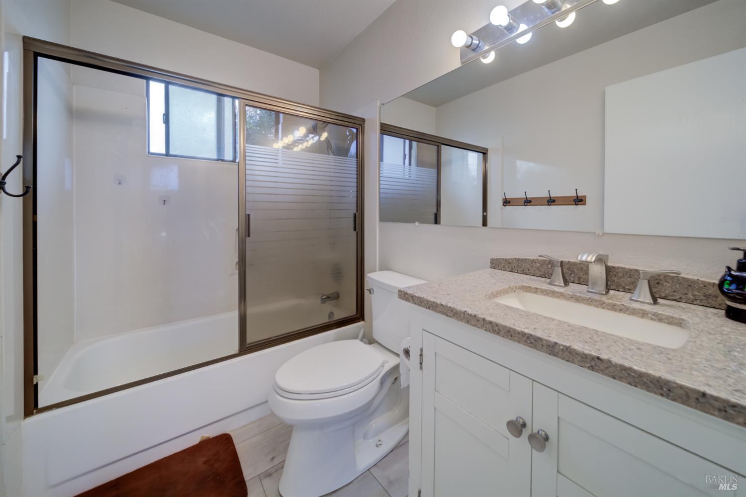 989 Suffolk Way Fairfield, CA 94533 - Photo 21 of 30 a bathroom with a granite countertop sink a toilet and shower