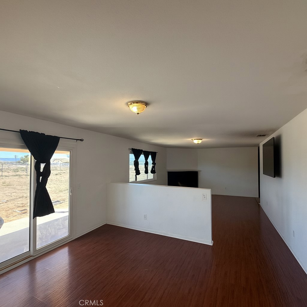 22665 Little Beaver Road Apple Valley, CA 92308 - Photo 2 of 9 a view of empty room with wooden floor and fan