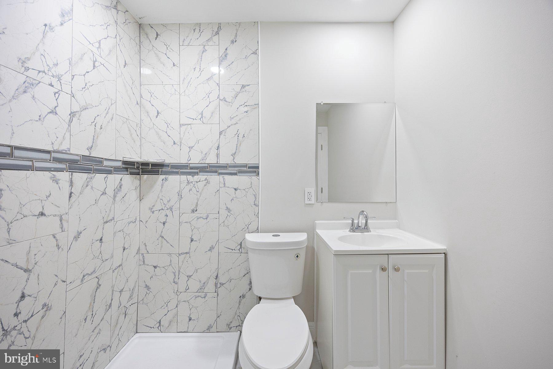 117 Collins Avenue Baltimore, MD 21229 - Photo 14 of 27 a bathroom with a toilet a sink and a shower curtain