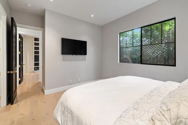 a bedroom with a large bed and a flat screen tv