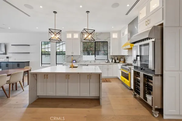 a large kitchen with stainless steel appliances kitchen island granite countertop a sink and cabinets