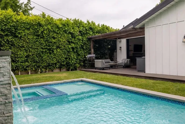 a view of swimming pool with lawn chairs and plants