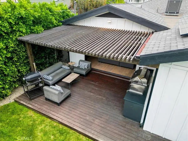 a roof deck with table and chairs and wooden floor