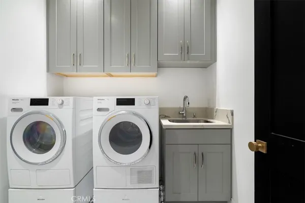 a utility room with sink dryer and washer