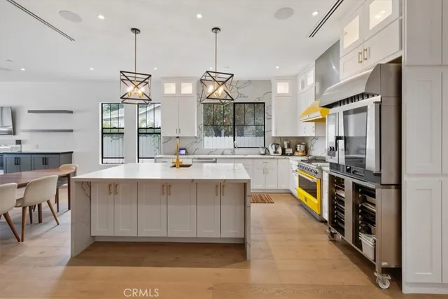 a large kitchen with stainless steel appliances kitchen island granite countertop a sink and cabinets