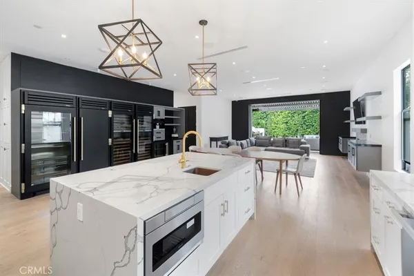 a kitchen with a stove a refrigerator and a dining table with wooden floor