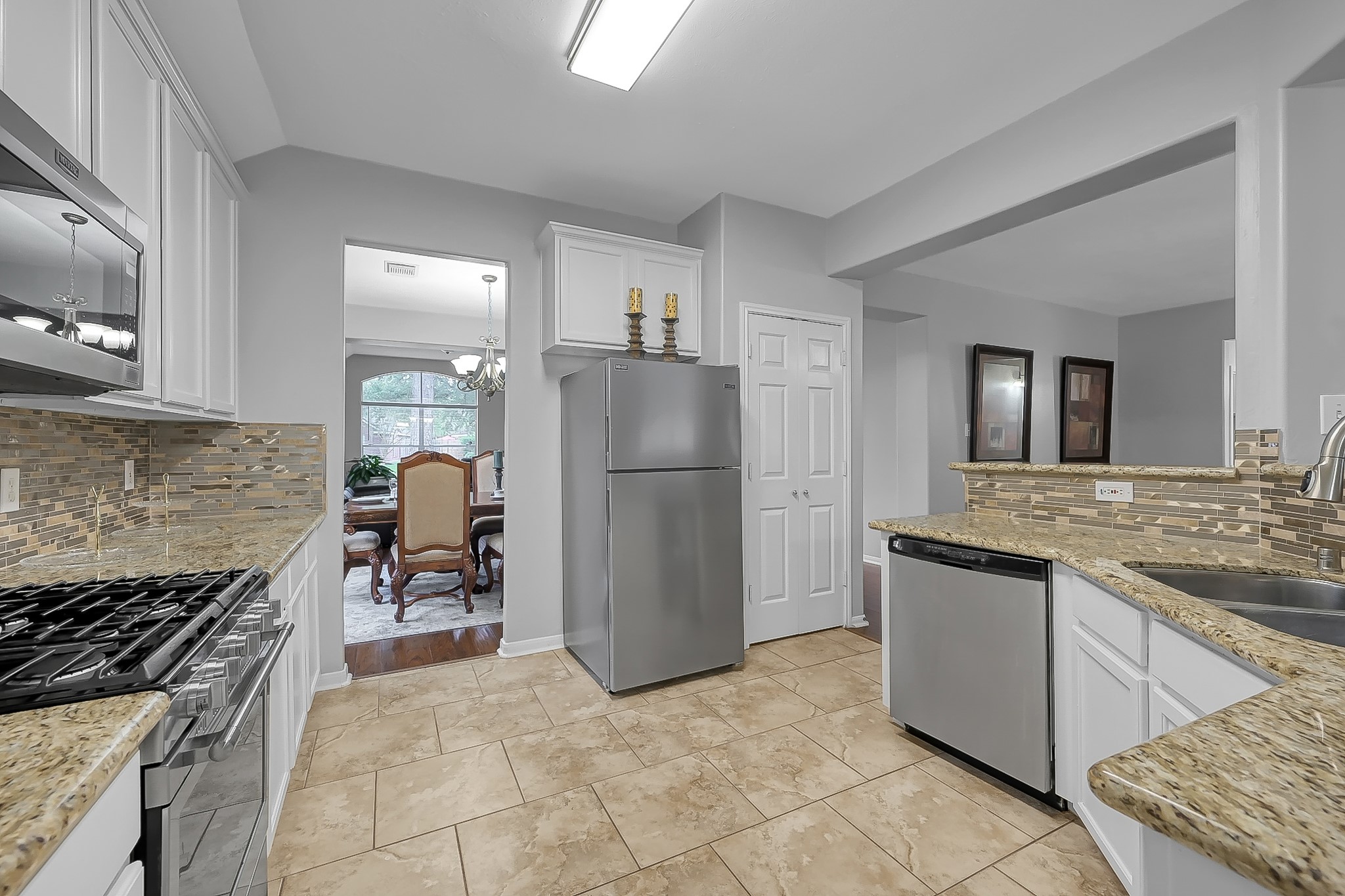 20251 Eden Pines Spring, TX 77379 - Photo 14 of 33 a kitchen with granite countertop a refrigerator and a stove top oven