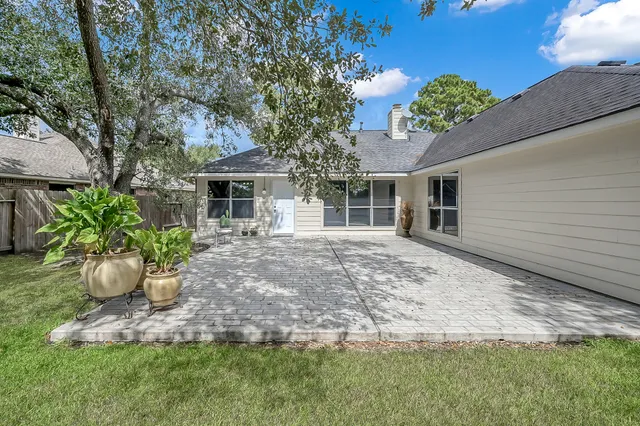 a view of a house with a yard and potted plants