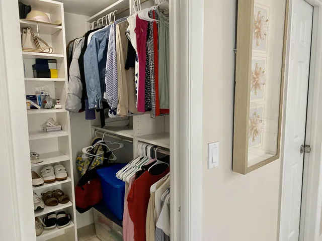 a view of walk in closet with clothes and shoes