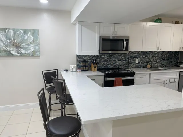 a kitchen with stainless steel appliances a stove a microwave a sink and cabinets