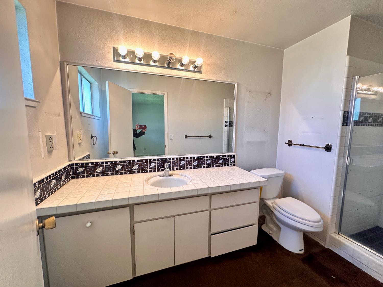 3207 Terry Way Carmichael, CA 95608 - Photo 27 of 36 a bathroom with a sink a toilet a mirror and shower