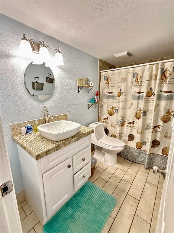3405 Clark Road, Unit 106 Sarasota, FL 34231 - Photo 13 of 19 a bathroom with a double vanity sink mirror and toilet