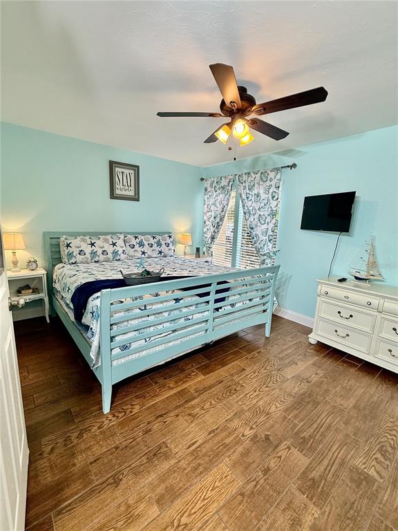 3405 Clark Road, Unit 106 Sarasota, FL 34231 - Photo 14 of 19 a bedroom with a bed and a chandelier