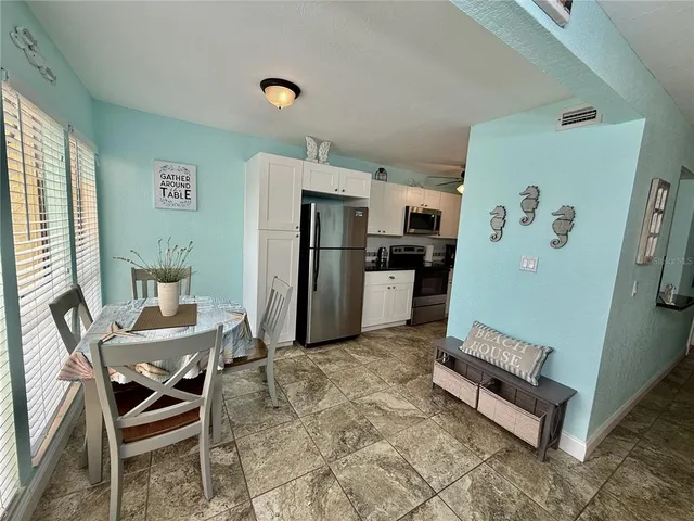 a living room with furniture and a refrigerator