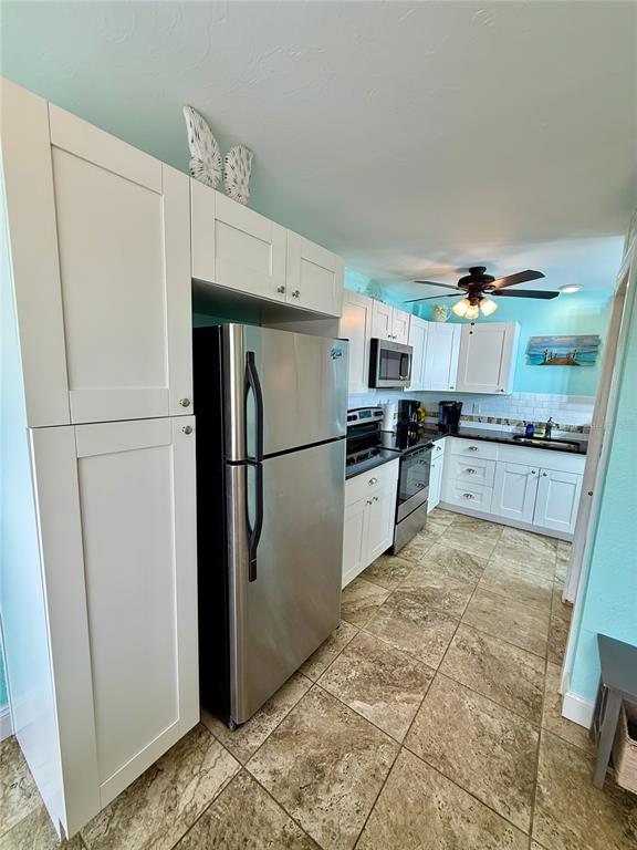 3405 Clark Road, Unit 106 Sarasota, FL 34231 - Photo 4 of 19 a kitchen with granite countertop a refrigerator and a stove top oven