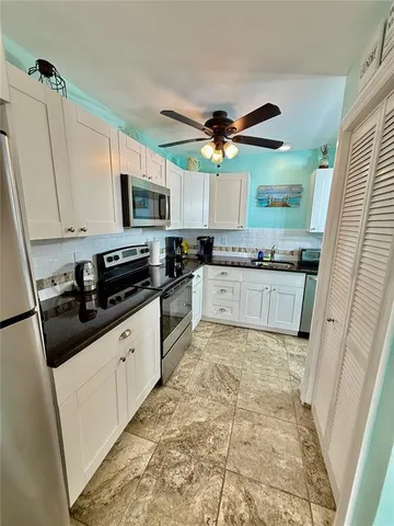 a kitchen with stainless steel appliances granite countertop a stove top oven a sink a stove a microwave a counter top space and cabinets