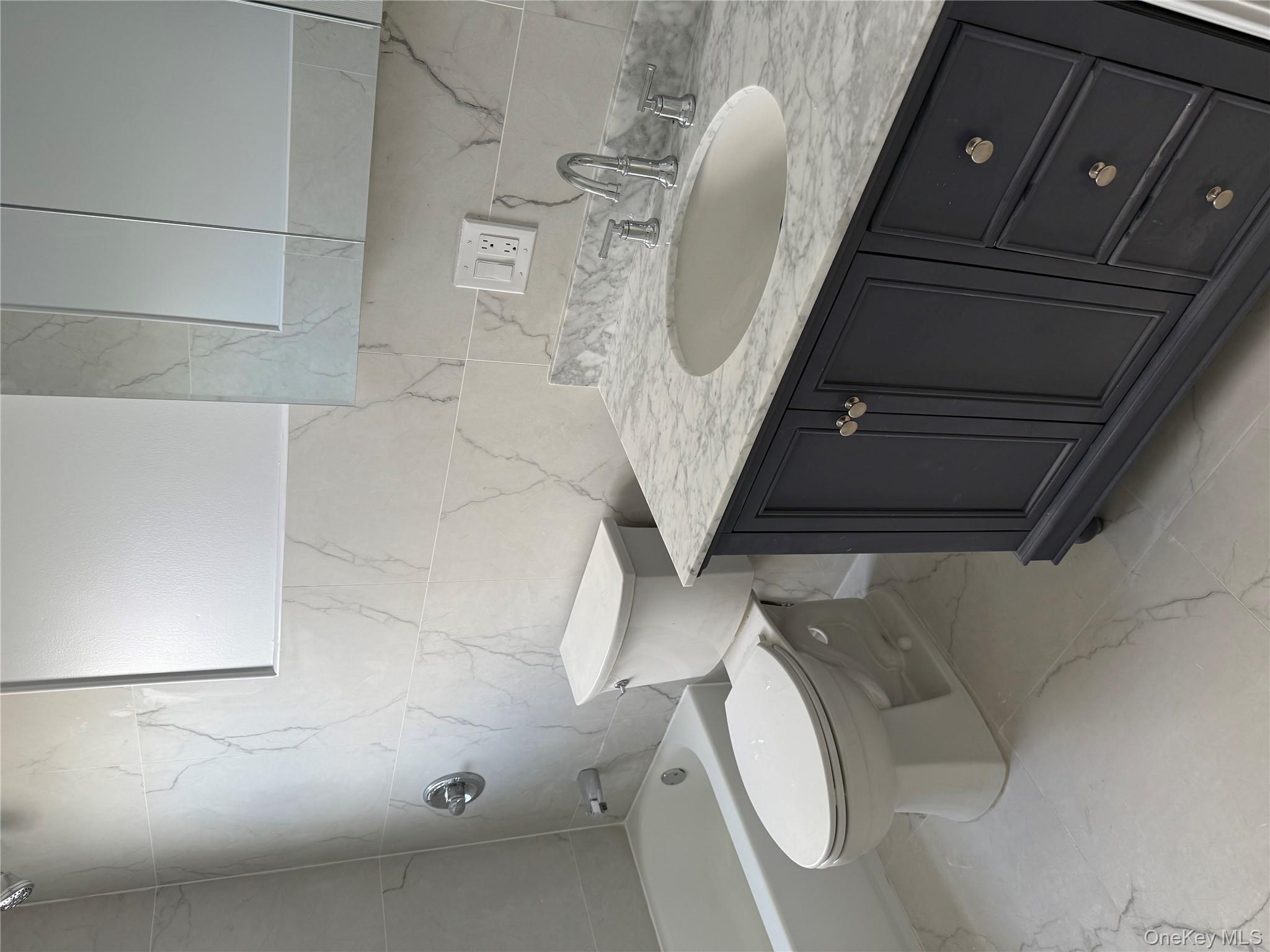 107-31 121st Street Queens, NY 11419 - Photo 12 of 20 a bathroom with a granite countertop toilet sink and mirror