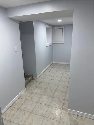 an empty room with cabinet and mirrors