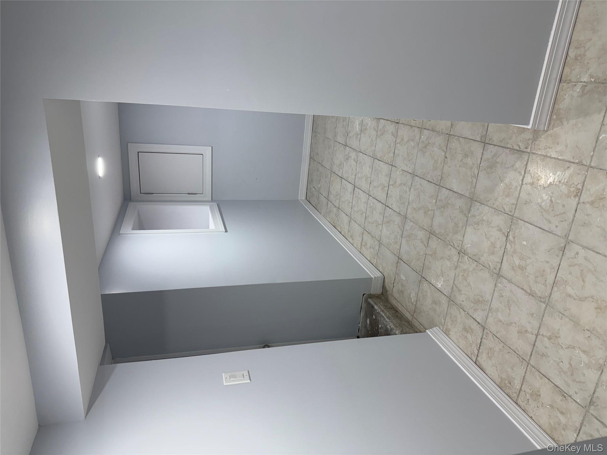 107-31 121st Street Queens, NY 11419 - Photo 13 of 20 an empty room with cabinet and mirrors