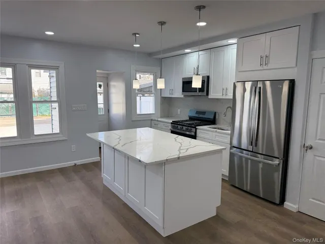 a kitchen that has a refrigerator a sink and cabinets