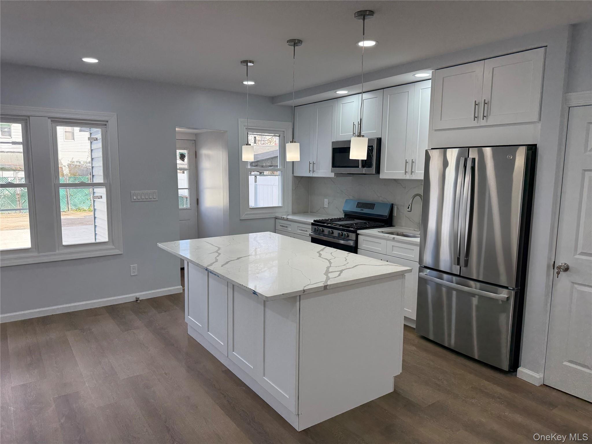 107-31 121st Street Queens, NY 11419 - Photo 3 of 20 a kitchen that has a refrigerator a sink and cabinets