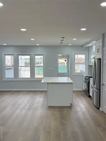a view of a kitchen with refrigerator and windows