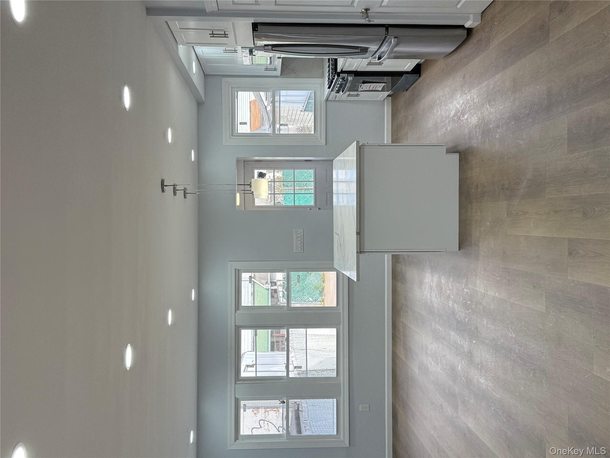 107-31 121st Street Queens, NY 11419 - Photo 5 of 20 a view of a kitchen with refrigerator and windows