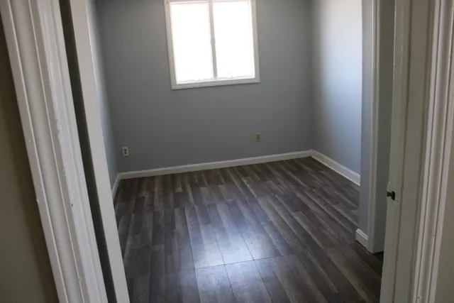 a view of a small space with wooden floor and a window