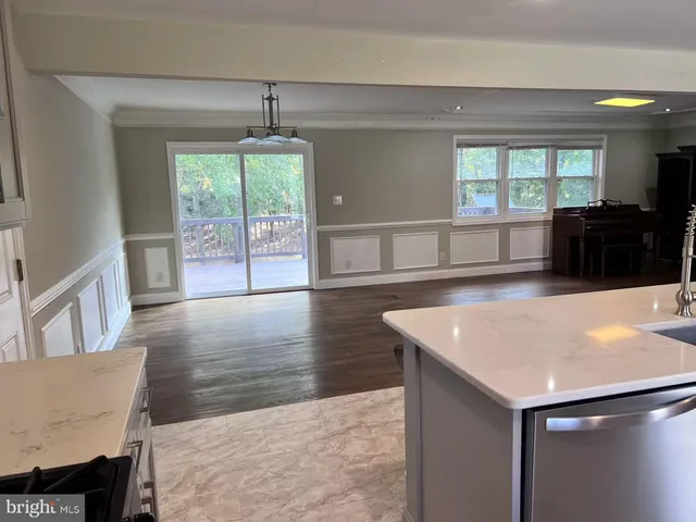 a view of a kitchen with furniture and wooden floor