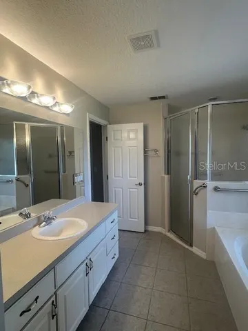 a spacious bathroom with a shower sink and mirror