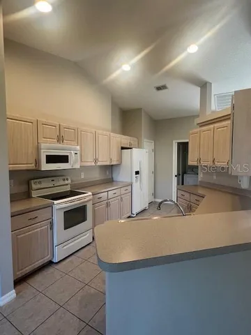 a kitchen with granite countertop a sink and white stainless steel appliances