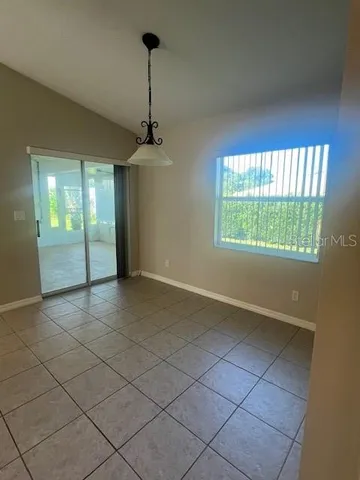 a view of a livingroom with a chandelier fan and windows