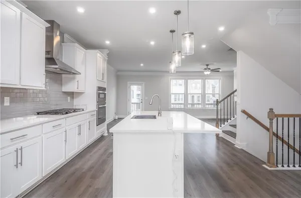 a large kitchen with kitchen island a sink a center island stainless steel appliances and a center island