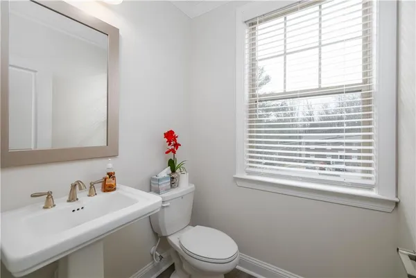 a bathroom with a sink a toilet and a window
