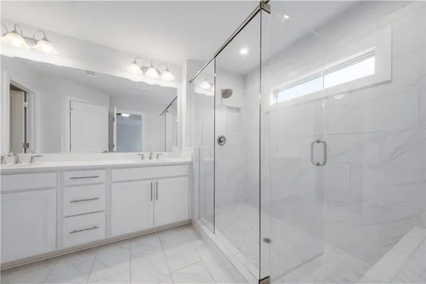 a bathroom with a shower sink and mirror